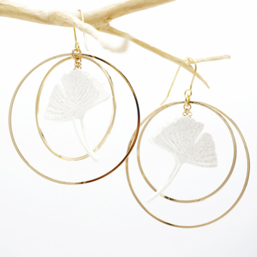 Ginko leaf earring framed by two gold-plated hoop earrings