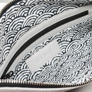 Faltbare Clutch aus feinem Leder mit Schultergurt und zahlreichen Reißverschlusstaschen
