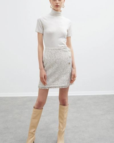 Jupe en tissu chiné blanc et rose pastel effet portefeuille garni de franges