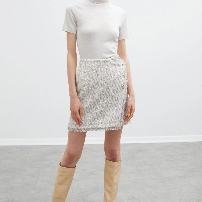 Jupe en tissu chiné blanc et rose pastel effet portefeuille garni de franges