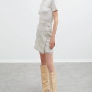 Skirt in white and pastel pink heather fabric with a wrap effect trimmed with fringes