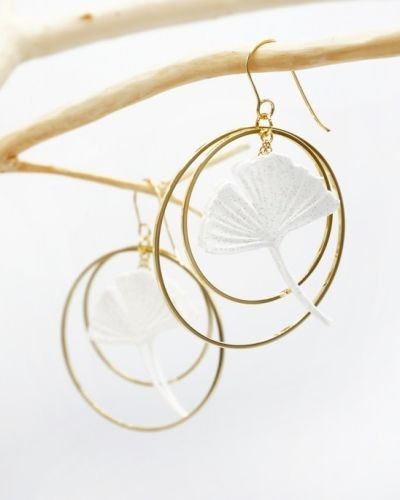 Boucles d&rsquo;oreille feuille de ginko encadrée de deux créoles dorées.
