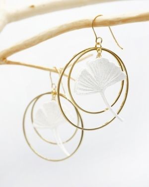 Boucles d’oreille feuille de ginko encadrée de deux créoles dorées.