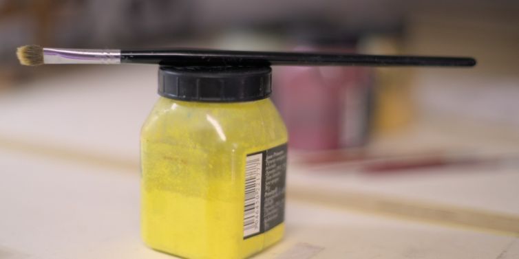 Pot de peinture et son pinceau.