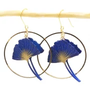 Boucles d&rsquo;oreille feuille de ginko encadrée de deux créoles argentées.
