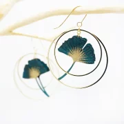 Ginko Blatt Ohrringe umrahmt von zwei goldenen Creolen.