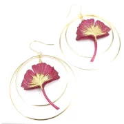 Ginko leaf earrings framed with two golden hoop earrings.