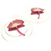 Ginko leaf earrings framed with two golden hoop earrings.